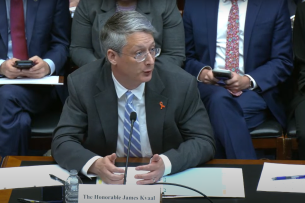 Under Secretary James Kvaal, a light-skinned man with gray hair, sits a table during a House hearing.